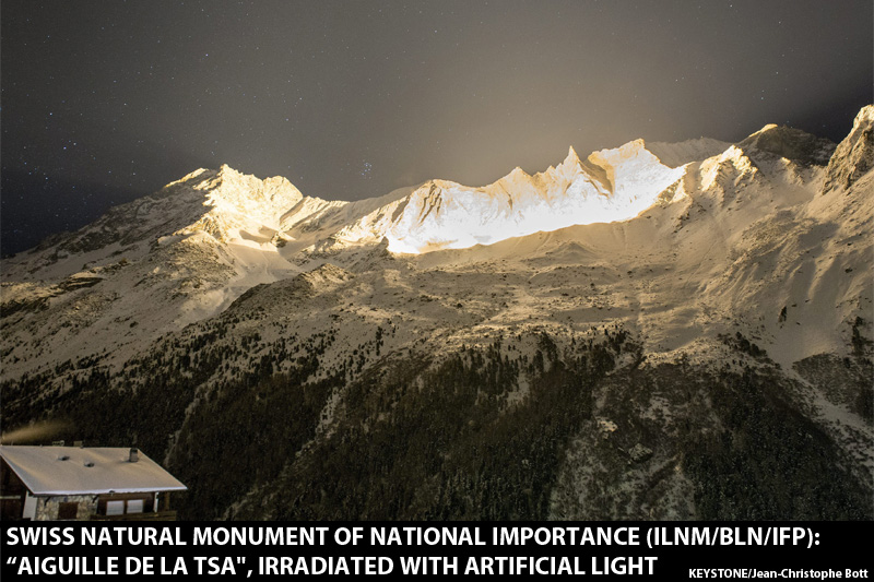 Une illumination coloree est visible au sommet de la montagne "aiguille de la Tza" lors d'un test du "Projet Etoile: 13 etoiles au sommet" ce mardi soir 26 novembre 2013 a Arolla en Valais. Ce projet est un des projets qui vont marque les festivites des 200 ans de l'entree du Valais dans la Confederation Suisse en 2015. (KEYSTONE/Jean-Christophe Bott)